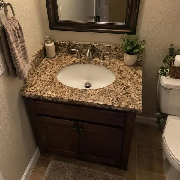 Granite vanity top with an undermount sink fitted wall to wall in a compact Baltimore bathroom