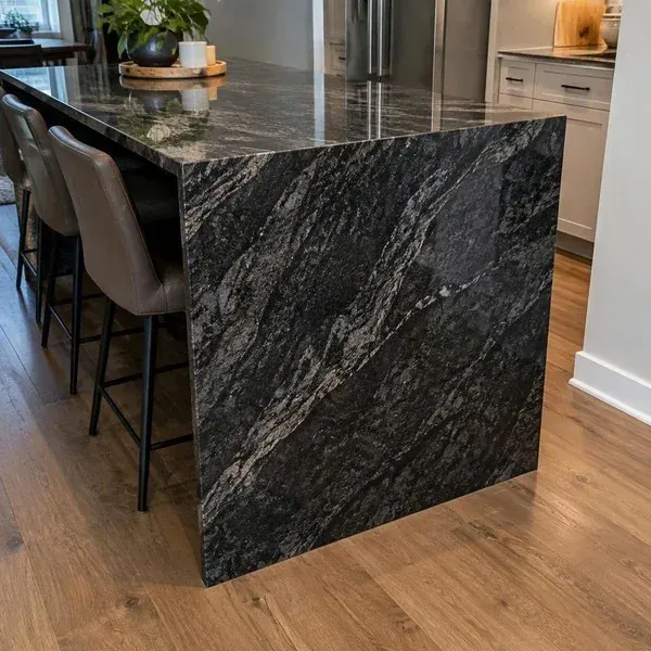 Granite waterfall side panel meeting the finished floor at the end of a kitchen island
