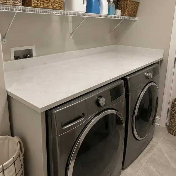 Quartz laundry room countertop installed above a washer and dryer for an easy-clean folding surface