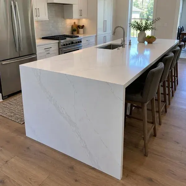 White veined quartz waterfall island with the panel running to the floor, compared with natural quartzite