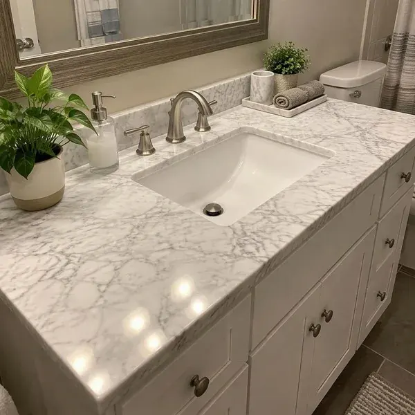 Refinished white marble bathroom vanity top with an undermount sink and an even polish across the stone