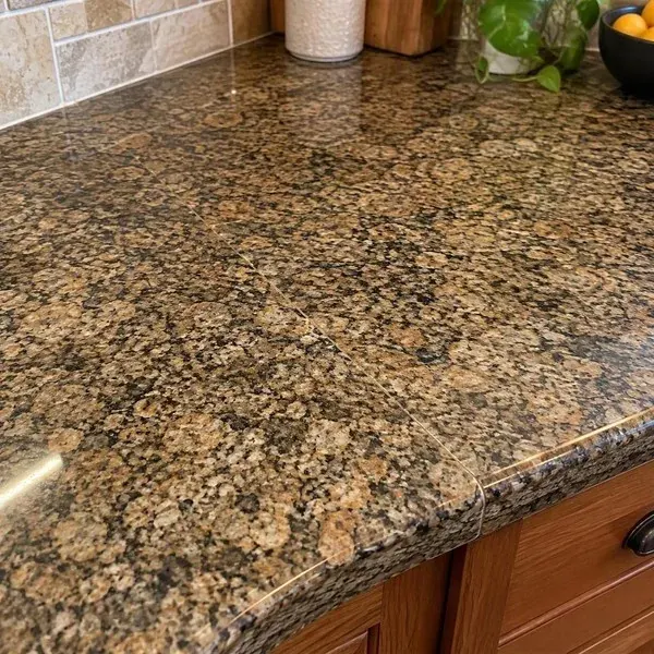 Close-up of a tight, flush seam in a speckled granite countertop with color-matched fill